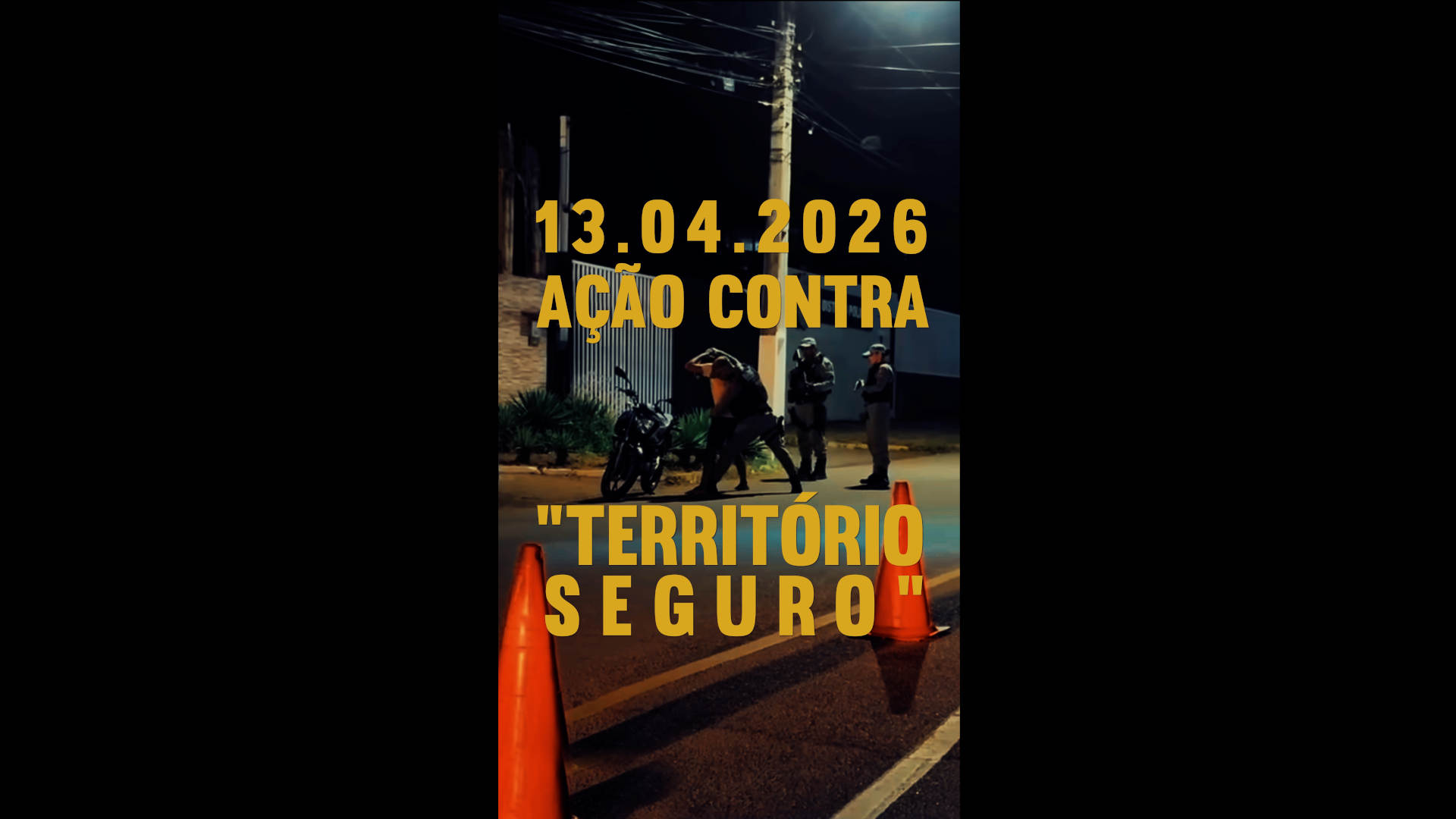 Foto mostra dois policiais à noite em uma rua mal iluminada, abordando um homem que está com as mãos na cabeça. Sobre a imagem o texto em amarelo: 13.04.2026 - Ação Contra "Território Seguro"