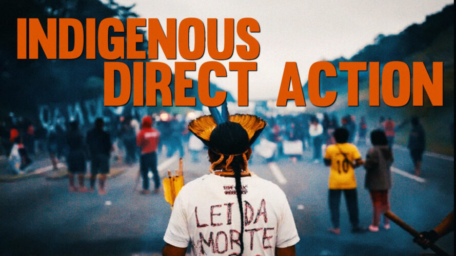 Cover of the video “Indigenous Direct Action” featuring the title in large orange letters over a photograph of an Indigenous person seen from behind, wearing a headdress, looking ahead at a group of diverse Indigenous people blocking the highway.